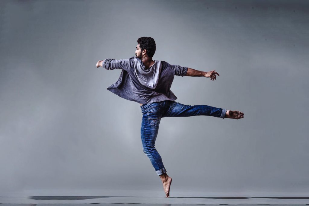 Male dancer performing against grey background