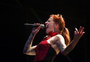 Woman singing into microphone on stage
